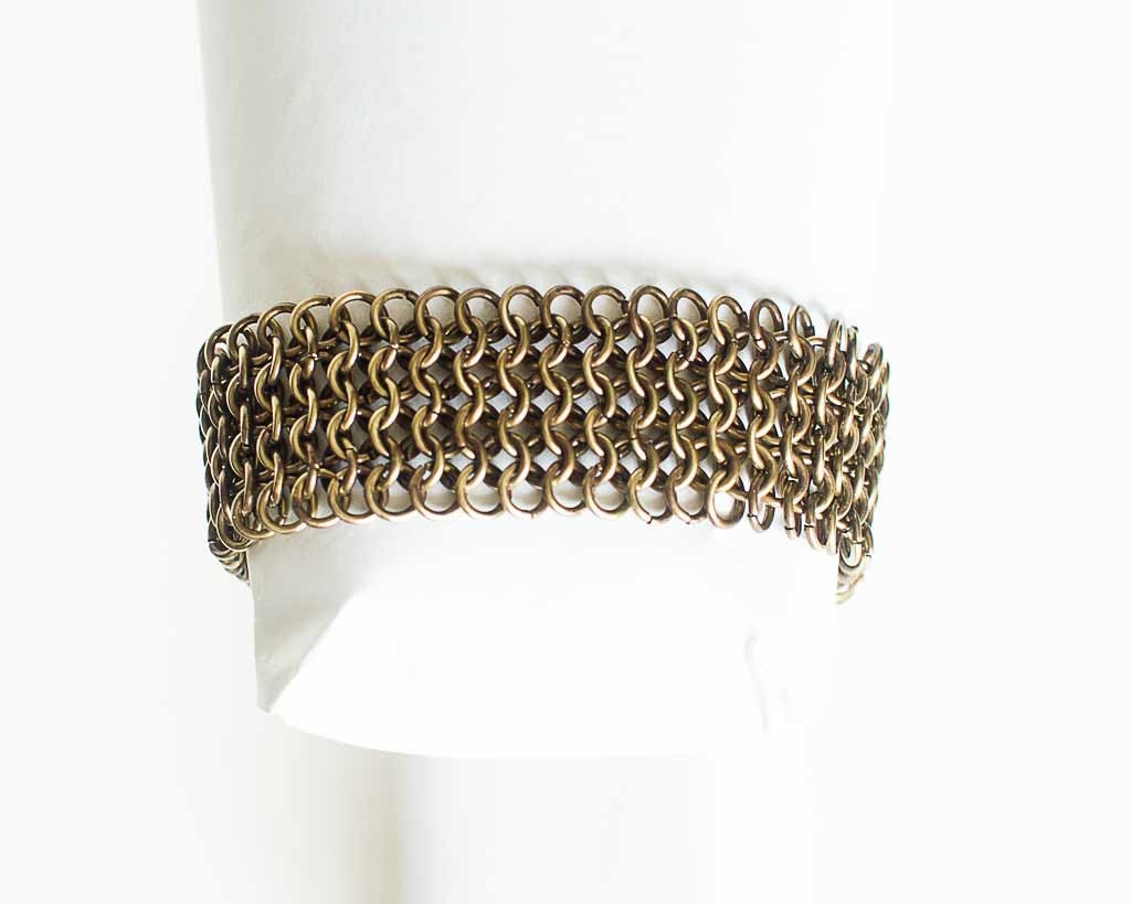 Brass chain bracelet on a white form on a white background